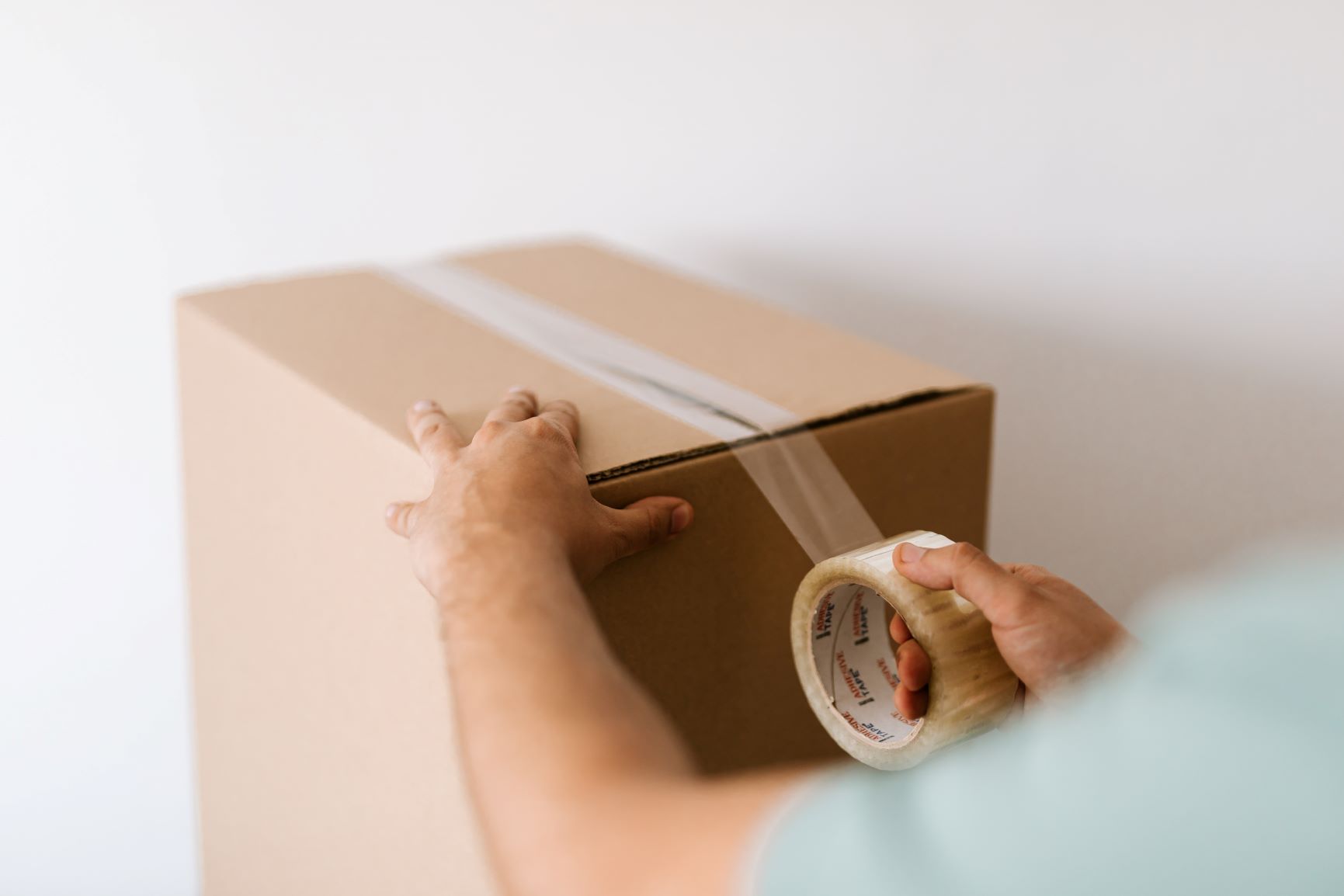 crop man sealing carton box with tape 4498139